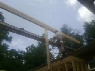 Carpenter setting a ridge beam over a new addition frame — Ice Dam Removal by Roofing Brothers in Berryville