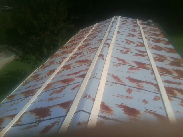 Rusted metal roof panels with new wood purlins before replacement — Storm Damage Roof Repair in Berryville by Roofing Brothers