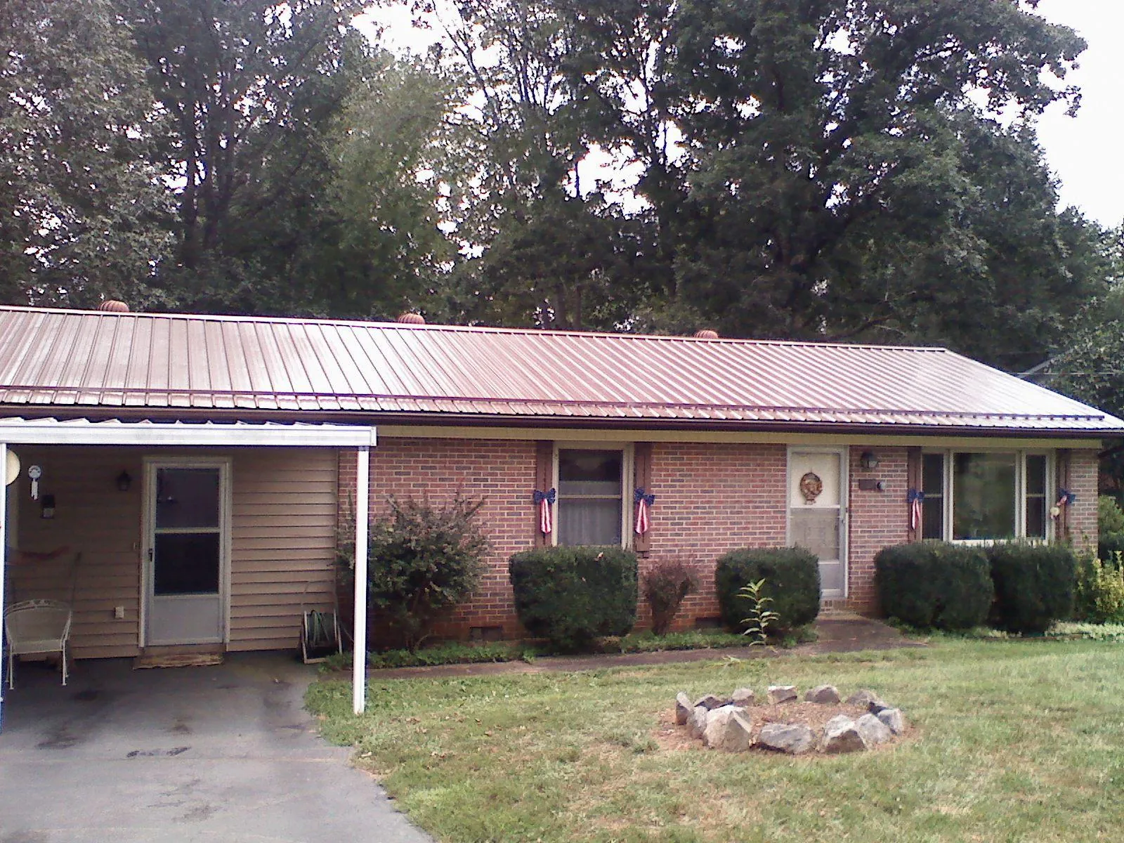 Bronze metal roof and carport on a brick ranch home — Roof Repair work by our crew in Berryville
