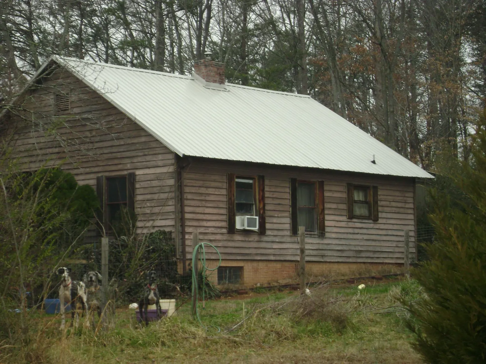 White metal roof on an old wood sided farmhouse, from a Metal Roof Installation job in Berryville
